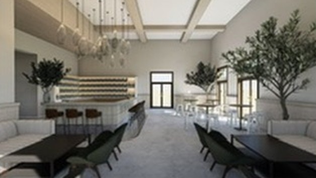 Indoor tables with upholstered chairs in Petit Domaine’s tasting room, with olive trees and pendant lights