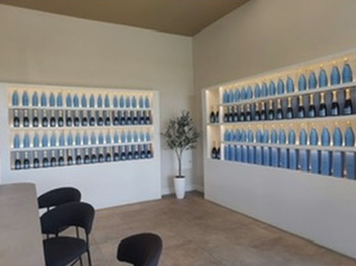 Two lit alcoves of sparkling wine bottles in the tasting room